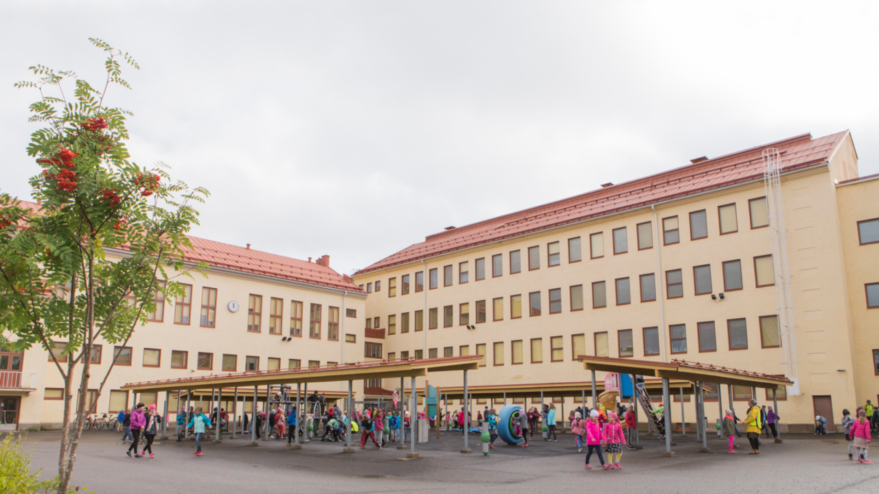 Kuva harjoittelukoulusta. Pihalla on oppilaita.