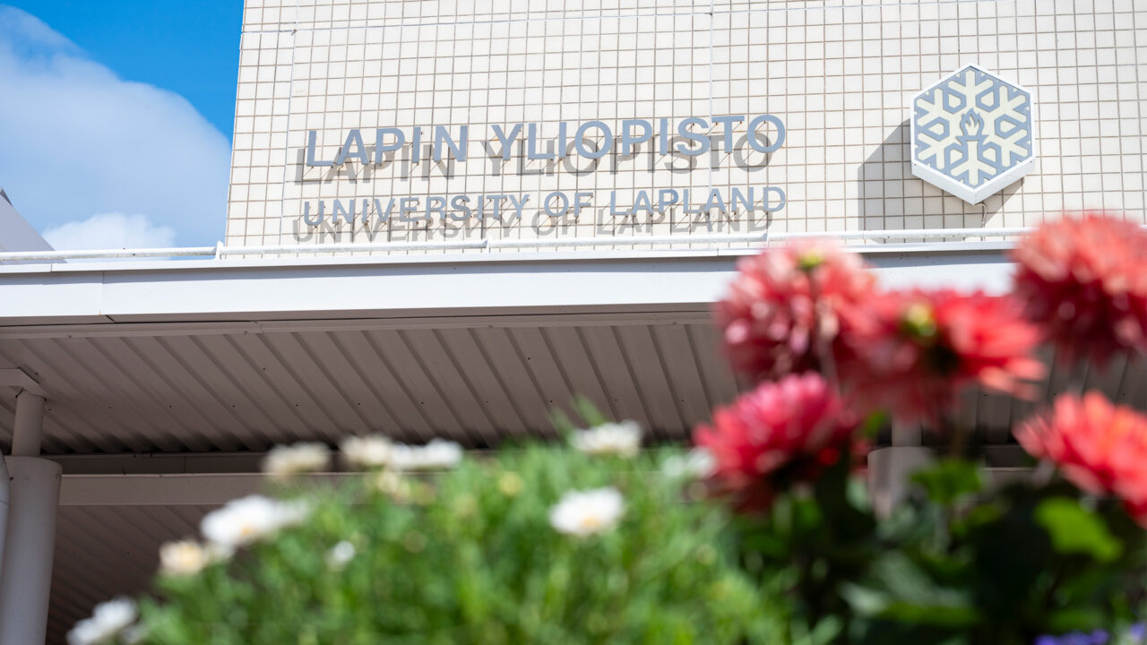 The main building of University of Lapland and red flowers.