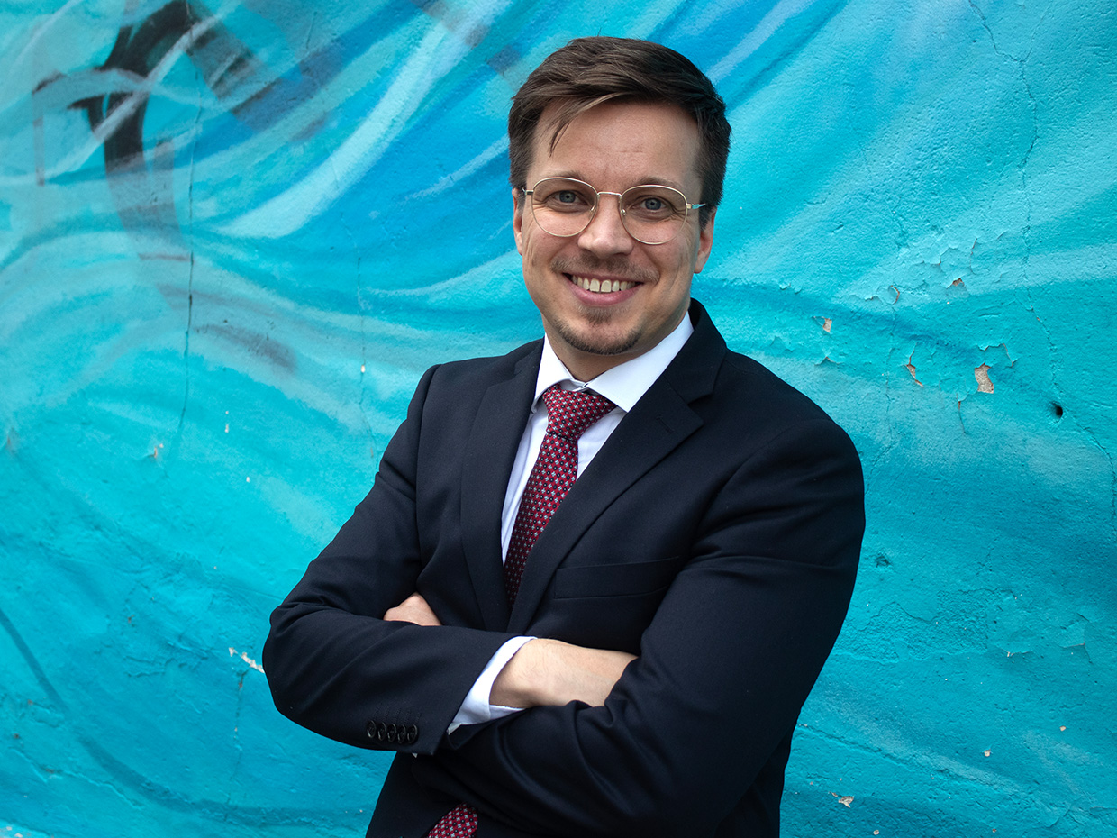 Juho Kähkönen taustallaan turkoosi seinämaalauksen osa.