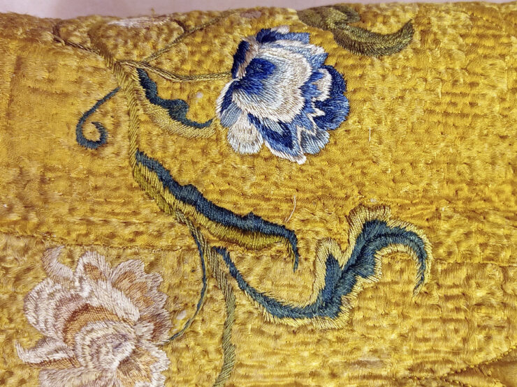 A detail of Govenius's yellow silk skirt, featuring embroidered flowers.